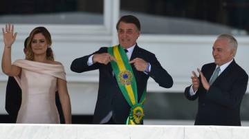 Jair Bolsonaro com a faixa presidencial ao lado de Michelle Bolsonaro e Michel Temer