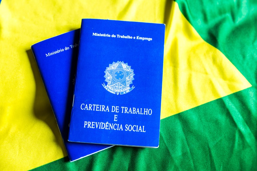 Duas carteiras de trabalho sobre uma bandeira do Brasil