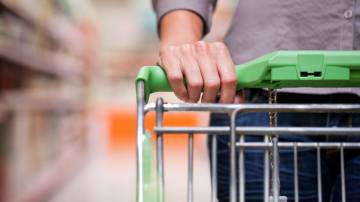 Homem empurrando carrinho de compras no supermercado