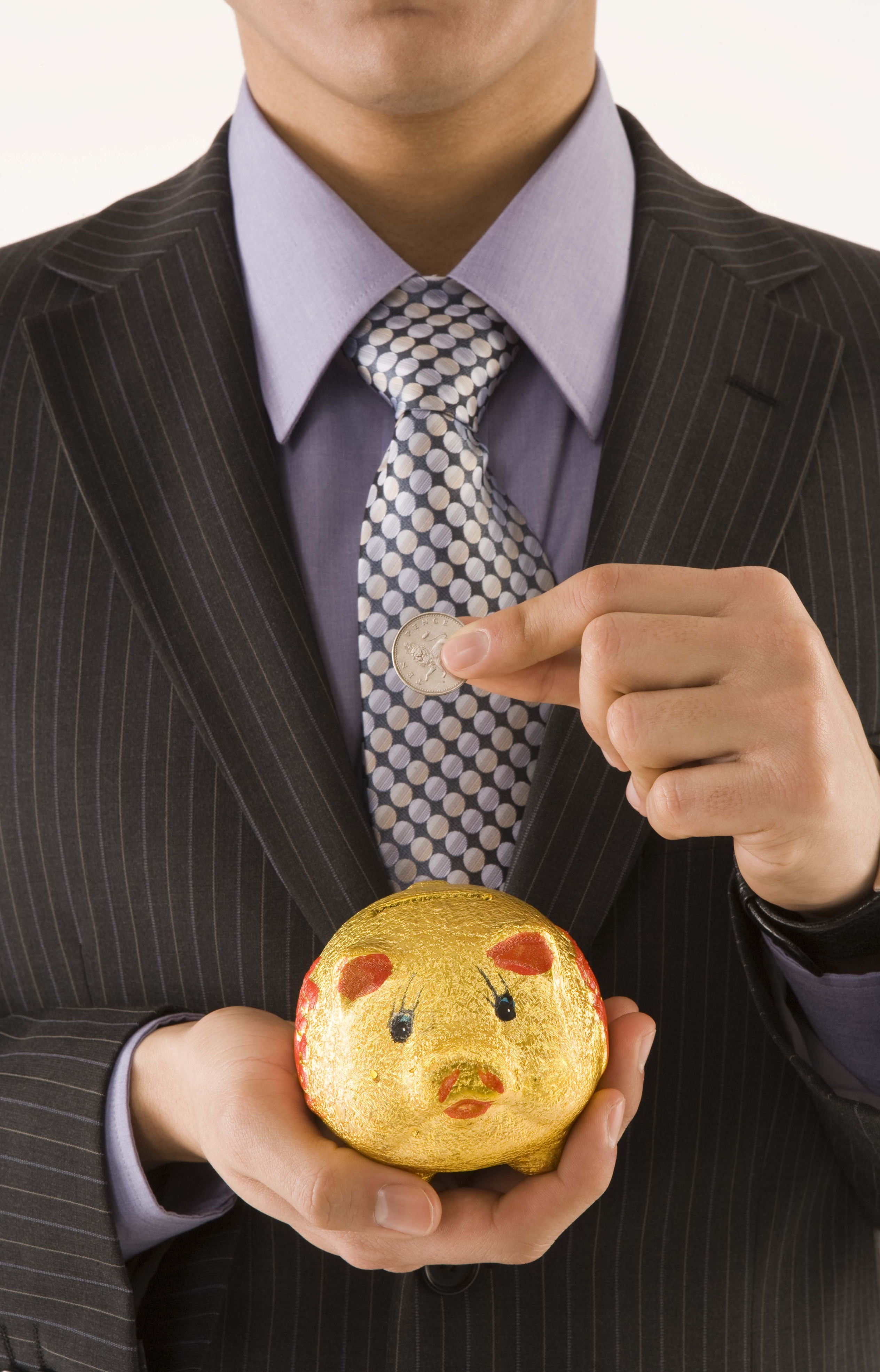 Businessman saving money in piggy bank