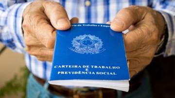 Homem idoso segurando carteira de trabalho