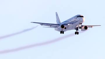 Trilhas de fumaça saindo dos motores de um avião