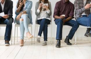Cinco pessoas sentadas à espera da entrevista de emprego