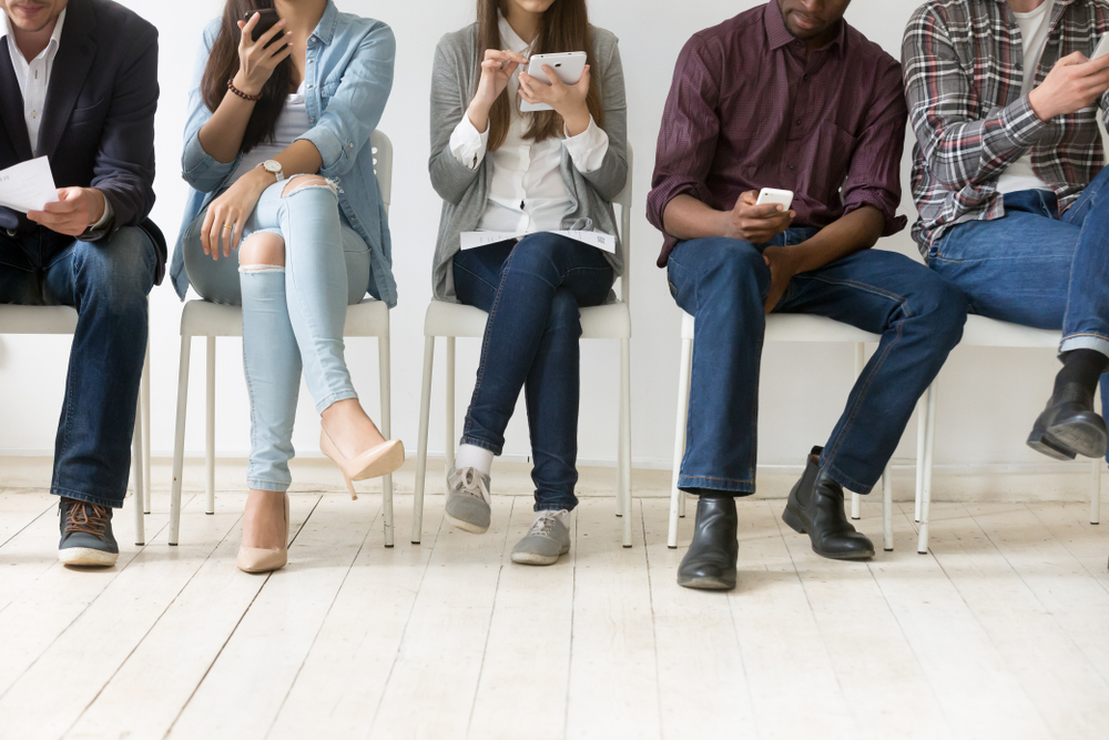 Cinco pessoas sentadas à espera da entrevista de emprego (Shutterstock)