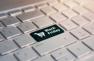 Teclado branco de computador onde a tecla "enter" foi substituída por uma tecla preta com um carrinho de compras escrito "black friday"