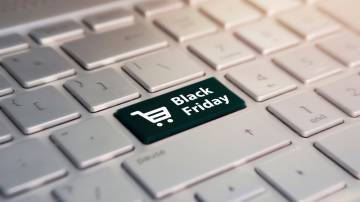 Teclado branco de computador onde a tecla "enter" foi substituída por uma tecla preta com um carrinho de compras escrito "black friday"