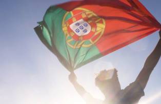 Homem segura bandeira de Portugal contra a luz