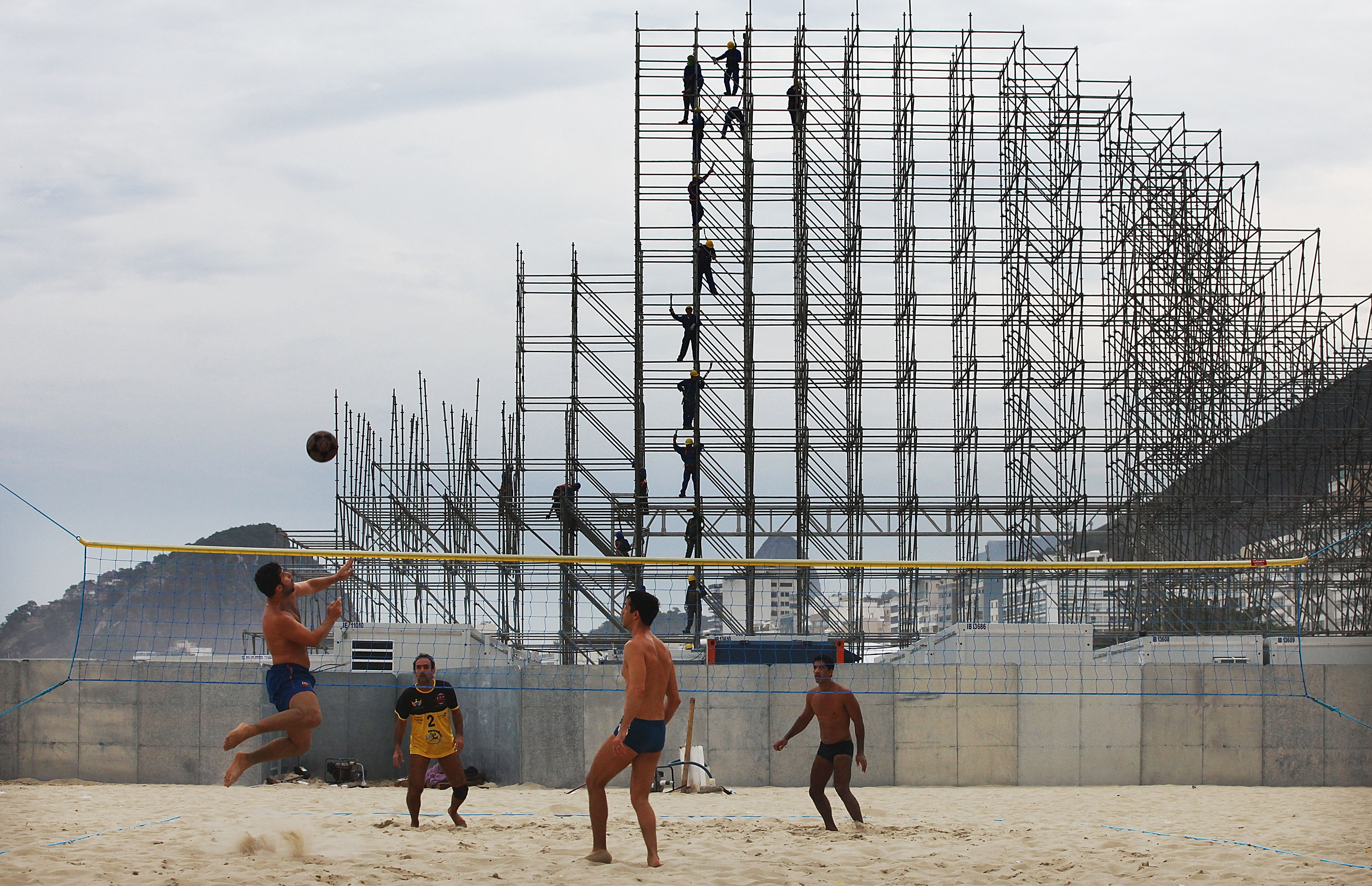 RIO DE JANEIRO, BRAZIL - JUNE 01:  People play footvolley, a form of soccer mixed with volleyball, near construction of the FIFA Fan Fest stage on Copacabana Beach on June 1, 2014 in Rio de Janeiro, Brazil. Brazil has won five World Cups, more than any other nation. The 2014 FIFA World Cup kicks off June 12 in Brazil.  (Photo by Mario Tama/Getty Images)