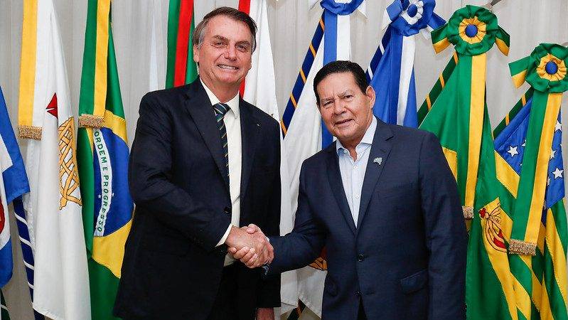 O presidente Jair Bolsonaro e o vice-presidente Hamilton Mourão cumprimentam-se e posam para foto (Foto: Alan Santos/PR)