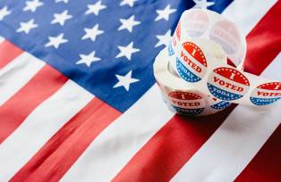 I vote today stickers roll, in US elections on American flag.