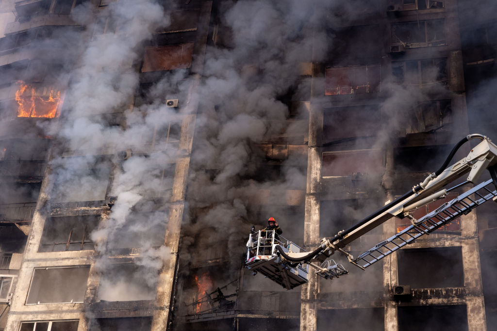 Bombeiros trabalham para extinguir incêndio em prédio residencial atingido por ataque russo nas primeiras horas da manhã no distrito de Sviatoshynskyi, em 15 de março de 2022, em Kiev, capital da Ucrânia. (Foto por Chris McGrath/Getty Images)