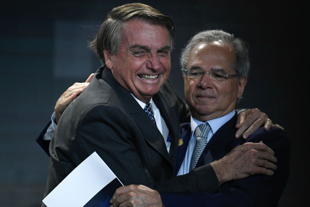 O presidente da República, Jair Bolsonaro (PL), cumprimenta o ministro da Economia, Paulo Guedes, durante reunião com empresários promovida pela CNI em 7 de dezembro de 2021 em Brasília (Foto de Mateus Bonomi/Getty Images)