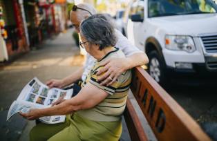 Casal lendo notícias da semana em jornal de papel