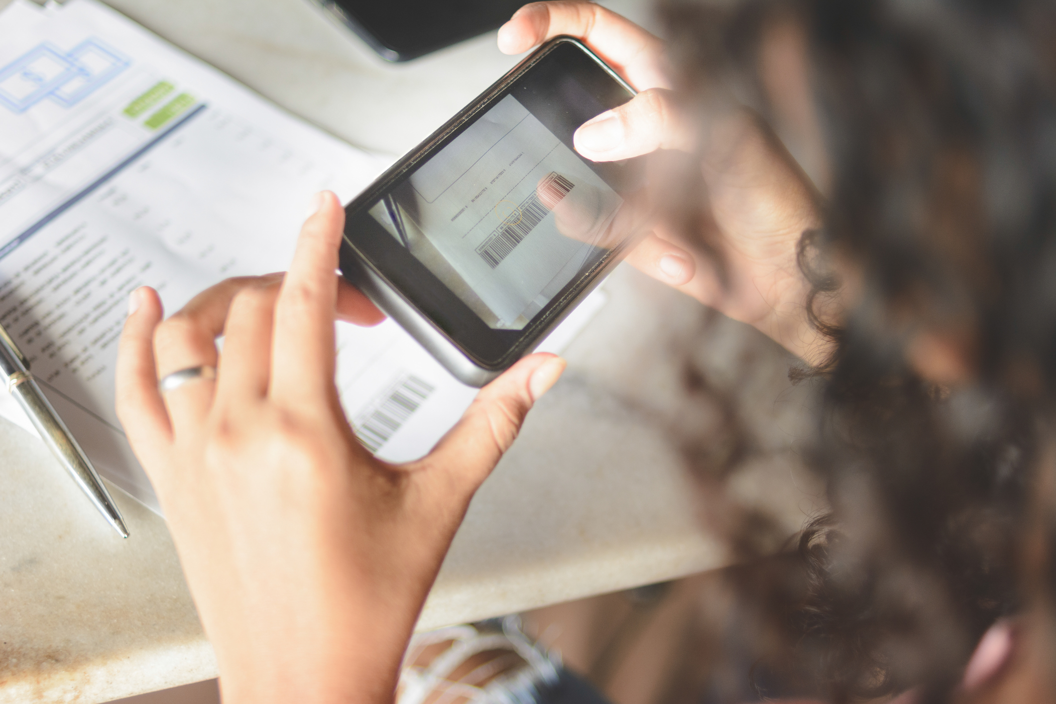 Mulher tira foto com smartphone para pagar conta de consumo, através do código de barras, via aplicativo do banco (Foto: Getty Images)