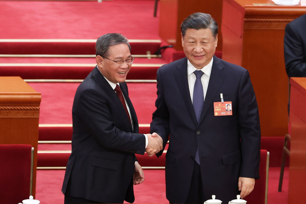 Li Qiang, o novo primeiro-ministro da China, cumprimenta o presidente chinês, Xi Jinping, após ser eleito para o cargo, durante a abertura da quarta sessão plenária do Congresso Nacional do Povo, em 11 de março de 2023, em Pequim (Foto de Lintao Zhang/Getty Images)