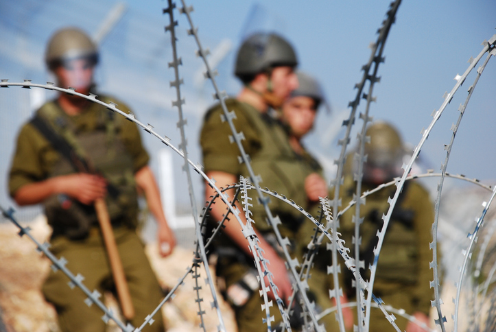 Quatro soldados israelenses atrás de arame farpado perto da vila palestina de Bil'in, na Cisjordânia (Foto: Getty Images)