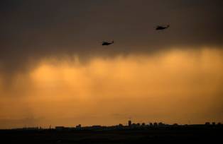 Helicópteros de ataque israelenses dirigem-se à fronteira sul de Israel com a Faixa de Gaza em 9 de outubro de 2023, perto de Ashdod, Israel. Em 7 de outubro, o grupo militante palestino Hamas lançou um ataque surpresa contra Israel a partir de Gaza, por terra, mar e ar, matando mais de 1.300 pessoas e ferindo milhares. Soldados e civis israelitas também foram raptados pelo Hamas e levados para Gaza. O ataque provocou uma declaração de guerra do primeiro-ministro israelita, Benjamin Netanyahu, e ataques retaliatórios contínuos de Israel em Gaza, matando centenas de pessoas. (Amir Levy/Getty Images)