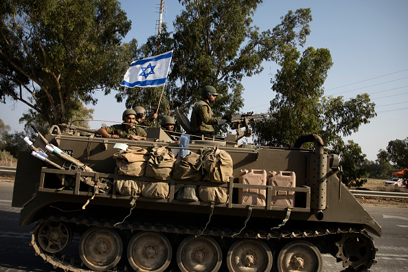 Soldados israelenses em um blindado segue em direção à fronteira sul com a Faixa de Gaza em 8 de outubro de 2023 em Sderot, Israel. No sábado (7), o grupo militante palestino Hamas lançou o maior ataque surpresa de Gaza em uma geração, disparando milhares de mísseis e um número desconhecido de combatentes por terra, que atiraram e sequestraram israelenses em comunidades perto da fronteira com Gaza. O ataque levou a ataques de retaliação a Gaza e uma declaração de guerra pelo primeiro -ministro israelense (Amir Levy/Getty Images)