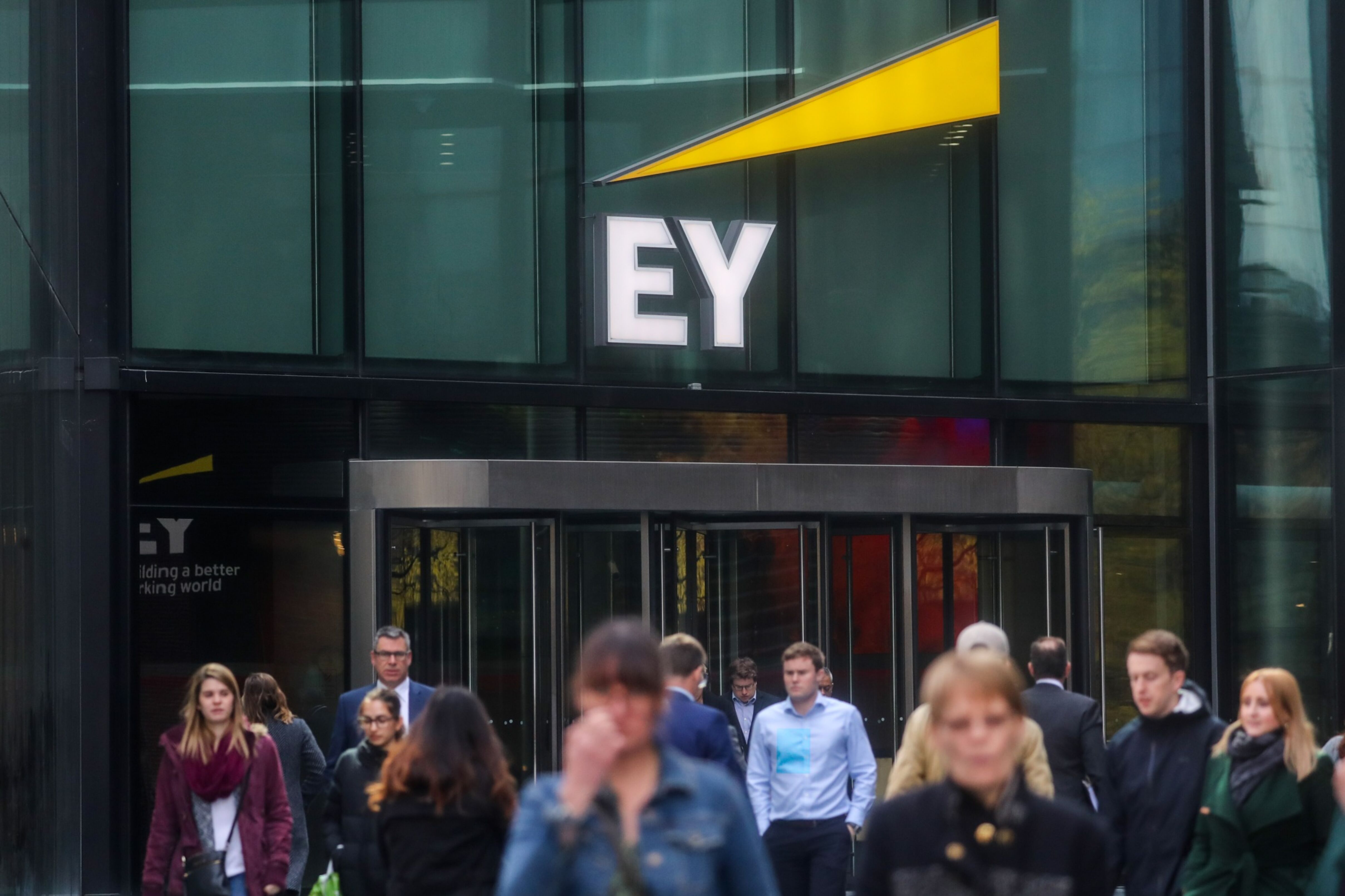 Pedestres passam em frente ao escritório da Ernst & Young em Londres (Simon Dawson/Bloomberg)