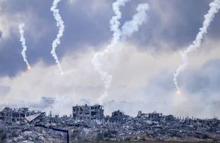 Esta foto tirada do sul de Israel, perto da fronteira com a Faixa de Gaza, mostra fumaça subindo após um ataque israelense, enquanto sinalizadores também são lançados sobre o norte de Gaza em 22 de novembro de 2023, em meio às batalhas contínuas entre Israel e o movimento palestino Hamas. Fotógrafo: John Macdougall/AFP/Getty Images