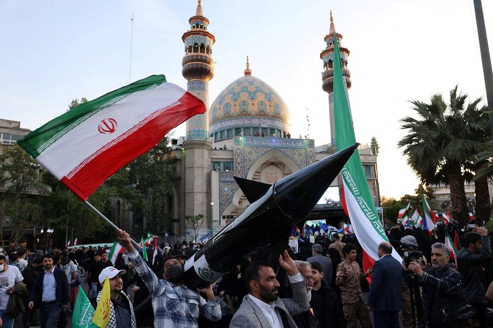 Iranianos com modelo de míssil durante celebração em Teerã
 15/4/2024    Majid Asgaripour/WANA (West Asia News Agency) via REUTERS