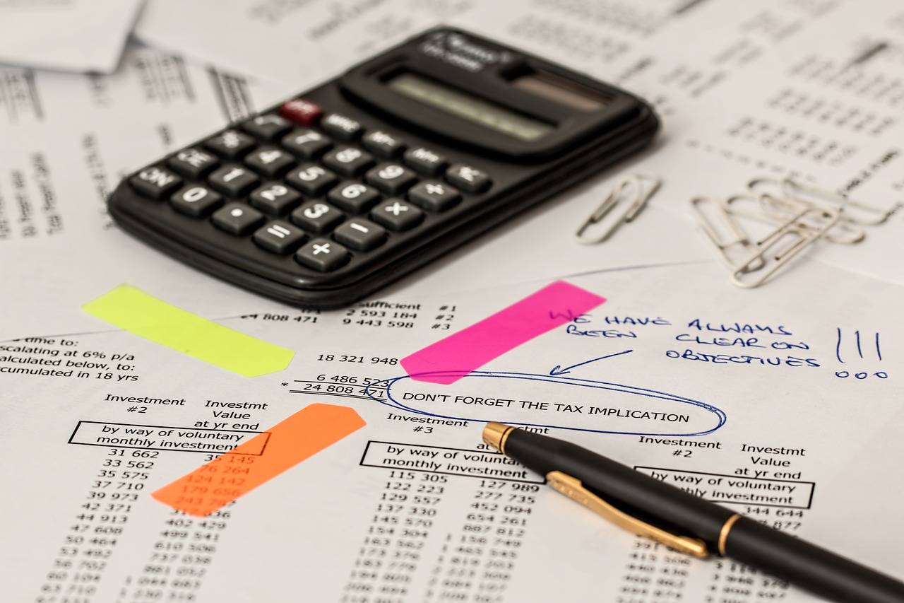 imagem mostra calculadora em cima de papéis riscados e post its