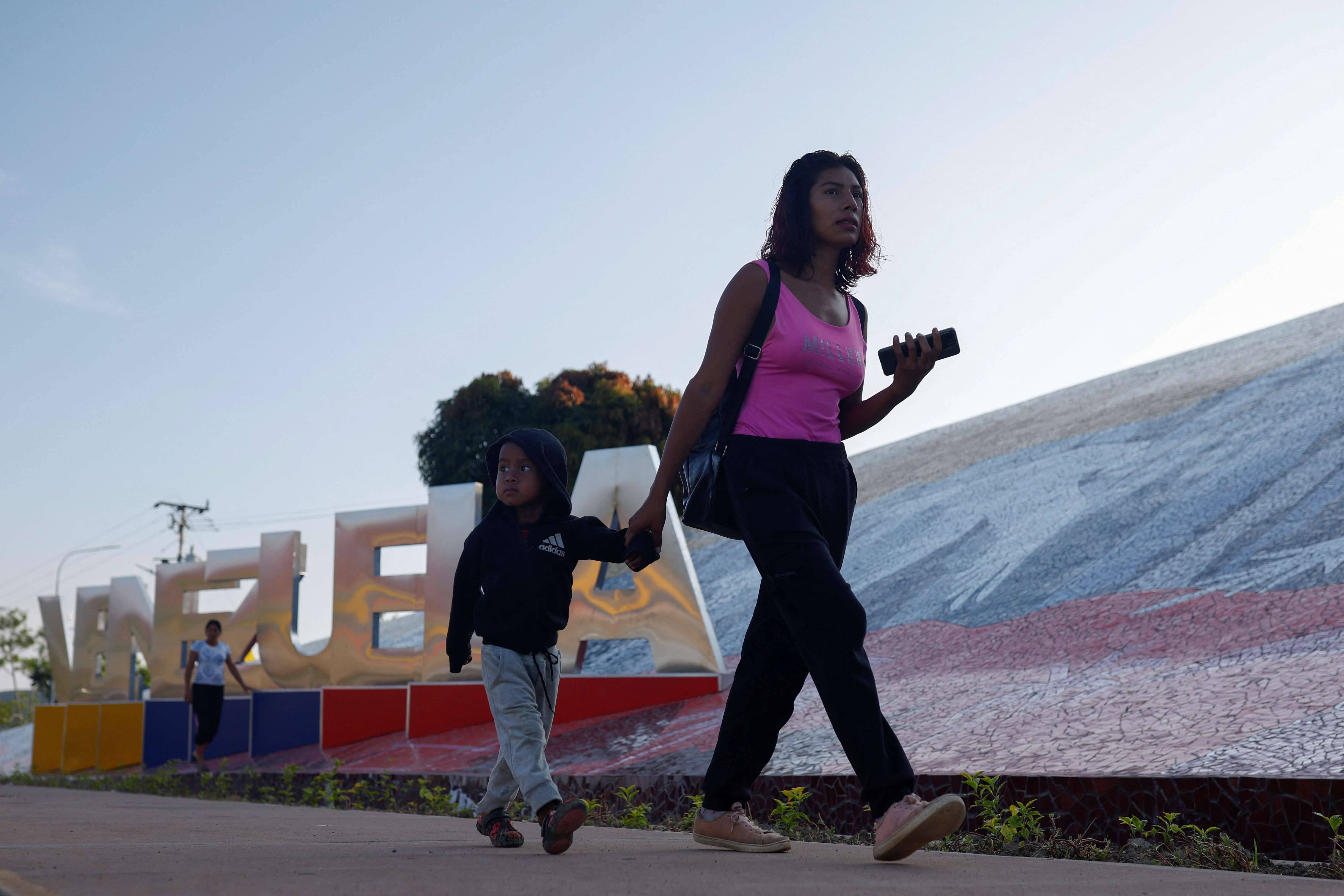 Mulher e criança cruzam a fronteira após deixar a Venezuela na cidade fronteiriça de Pacaraima, em Roraima 11/09/2024 (Foto: Amanda Perobelli/Reuters)
