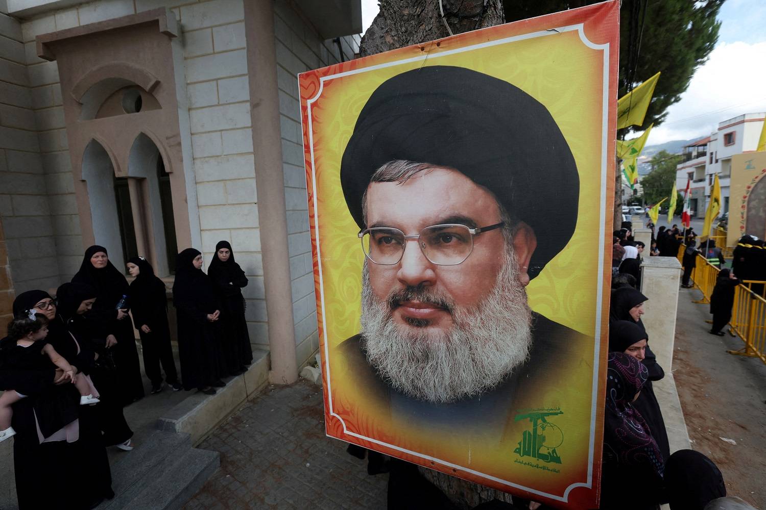 Pessoas se reúnem perto de uma imagem do líder do Hezbollah, Sayyed Hassan Nasrallah, durante o funeral do membro do Hezbollah, Ali Mohamed Chalbi, após rádios portáteis e pagers usados pelo Hezbollah detonarem em todo o Líbano, em Kfar Melki, Líbano, em 19 de setembro de 2024. REUTERS/Aziz Taher
