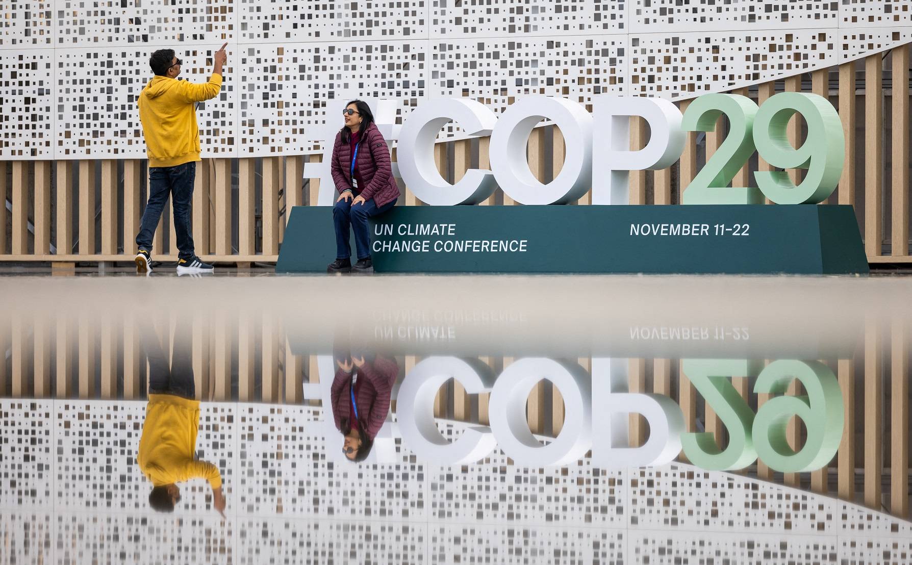 Pessoas tiram fotos na entrada do local da conferência da ONU de mudanças climáticas (COP29), antes do início da cúpula em Baku, Azerbaijão 
10/11/2024
REUTERS/Maxim Shemetov