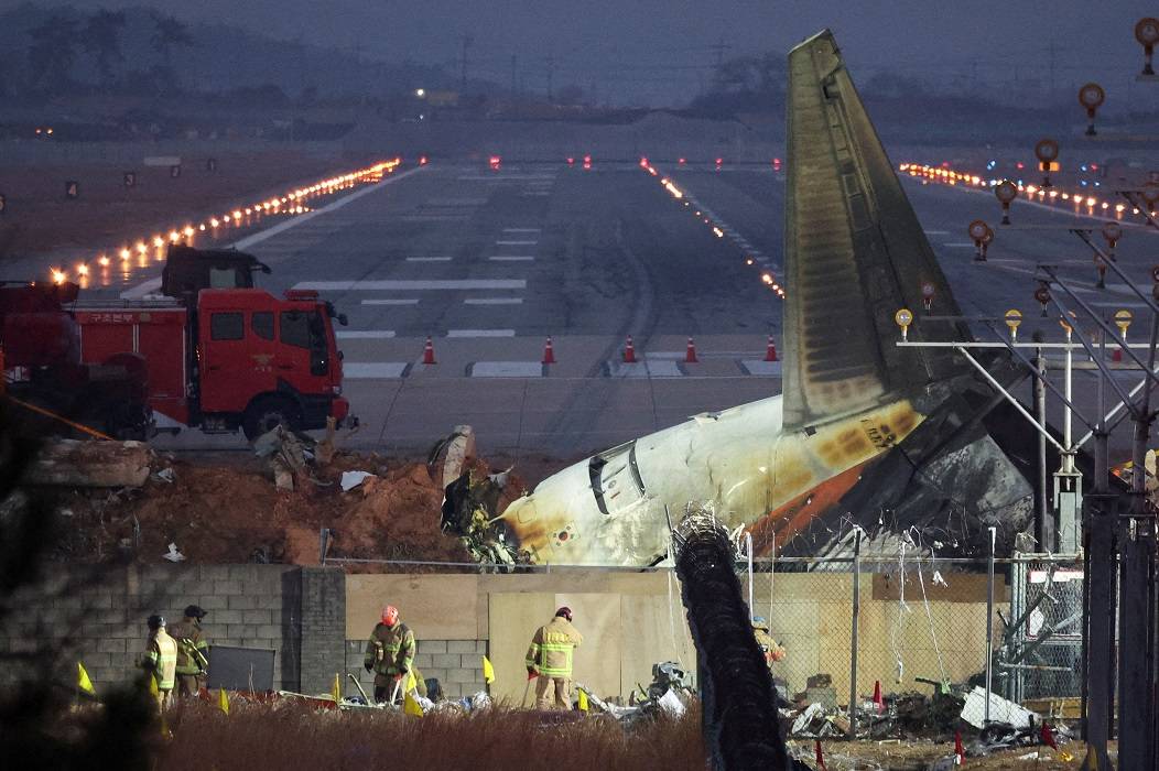 Socorristas trabalham perto dos destroços da aeronave da Jeju Air que saiu da pista e caiu no Aeroporto Internacional de Muan, em Muan, Coreia do Sul, em 30 de dezembro de 2024. REUTERS/Kim Hong-Ji