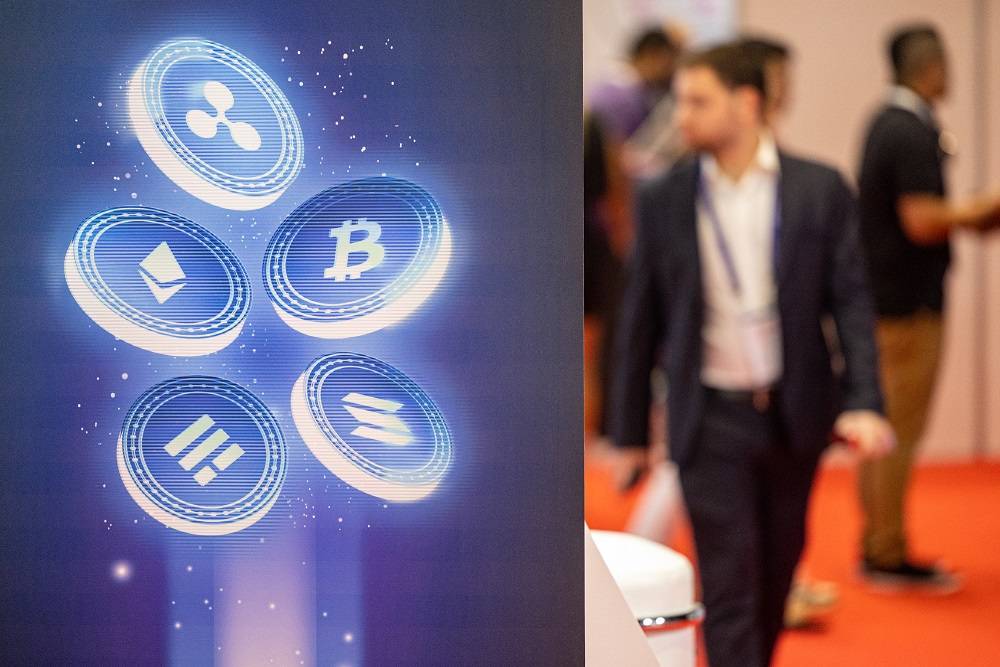 Os logotipos das moedas Ripple, Ethereum, Bitcoin, Binance USD e Solana estão em exibição no estande da Evest durante a Dubai Crypto Expo na Festival Arena em Dubai, Emirados Árabes Unidos, na quarta-feira, 8 de março de 2023. Fotógrafo: Christopher Pike/Bloomberg.

