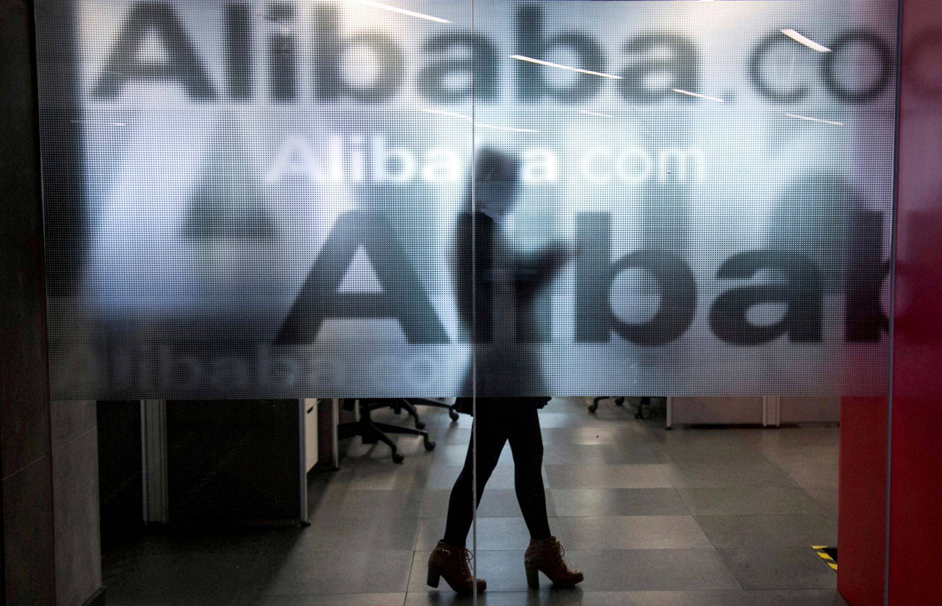Funcionária é vista atrás de uma parede de vidro com o logotipo do Alibaba na sede da empresa em Hangzhou, na China 23/04/2024 (Foto: REUTERS/Chance Chan)