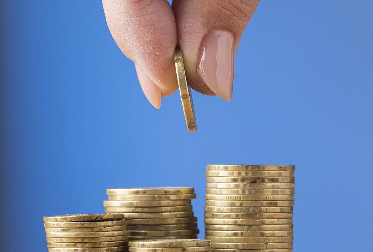 person-placing-coin-pile-coins