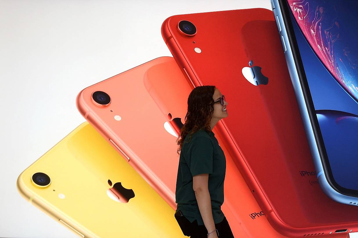 Um funcionário da Apple passa por uma ilustração de iPhones na nova Apple Carnegie Library durante a inauguração e a prévia para a mídia em Washington, EUA, em 9 de maio de 2019. REUTERS/Clodagh Kilcoyne/Foto de Arquivo.