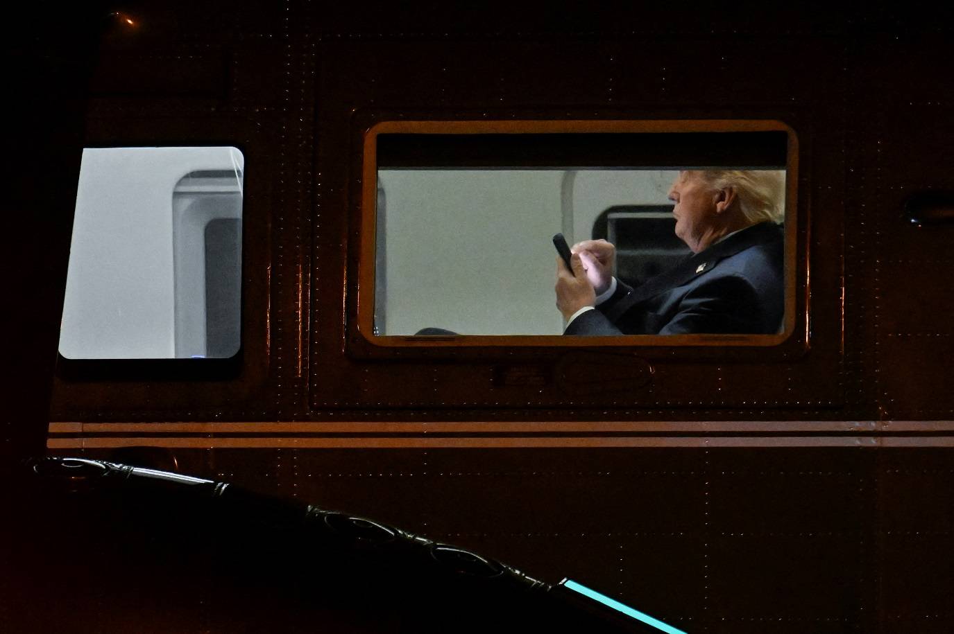 O presidente dos EUA, Donald Trump, usa seu telefone no Marine One no Aeroporto Executivo de Leesburg, em Leesburg, Virginia, EUA, em 24 de abril de 2025. REUTERS/Craig Hudson