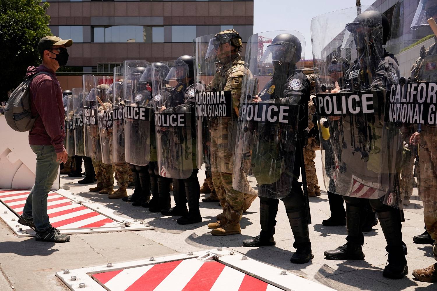 Um homem enfrenta membros das forças de segurança em frente ao edifício federal Edward R. Roybal, após dias de protestos contra as operações federais de imigração e o envio da Guarda Nacional da Califórnia e dos Fuzileiros Navais dos EUA, no centro de Los Angeles, Califórnia, EUA, 10 de junho de 2025. REUTERS/David Ryder


