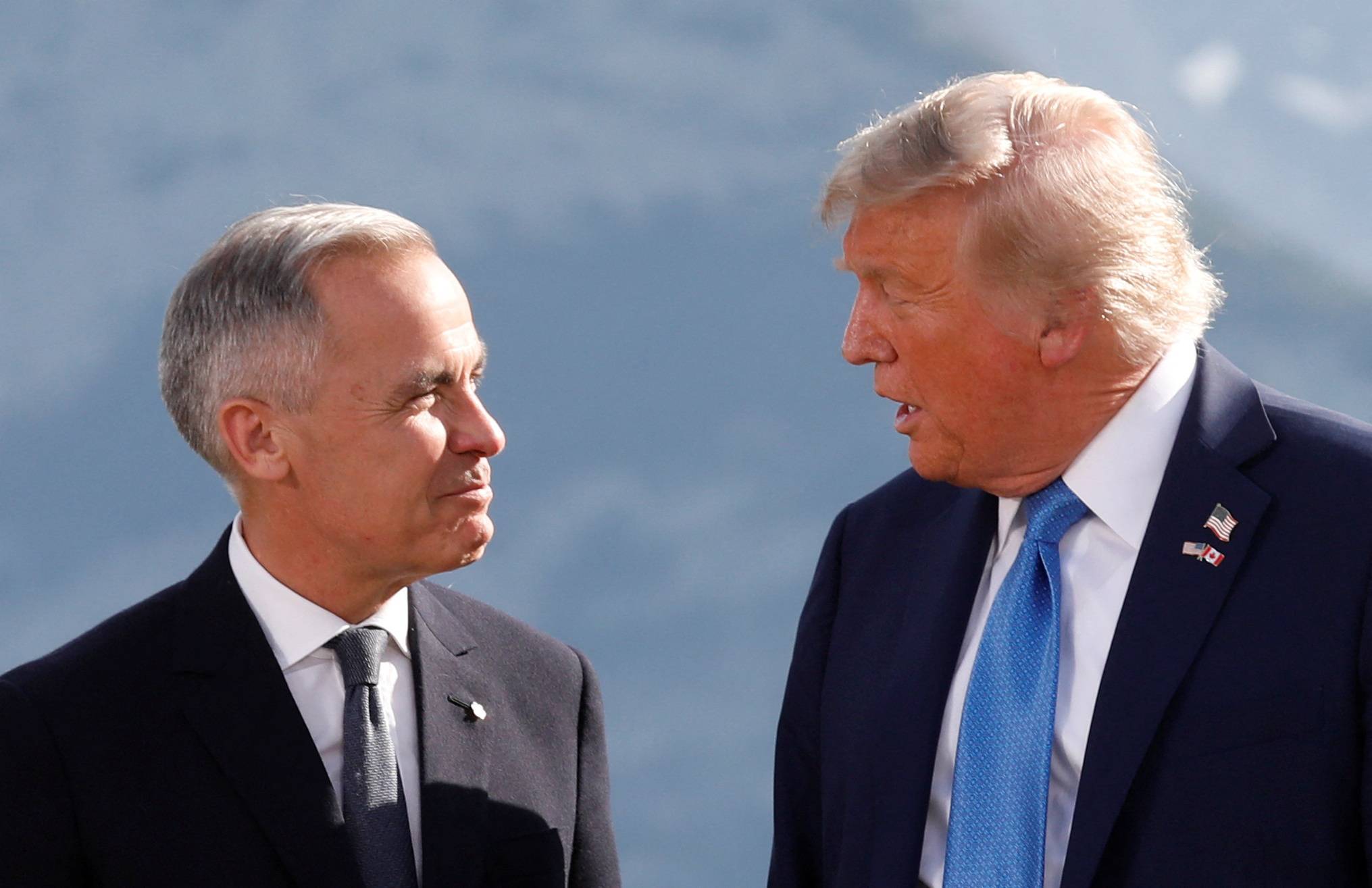 O presidente dos EUA, Donald Trump, e o primeiro-ministro do Canadá, Mark Carney, conversam durante uma foto de família na Cúpula do G7 em Kananaskis, Alberta, Canadá, em 16 de junho de 2025. REUTERS/Amber Bracken