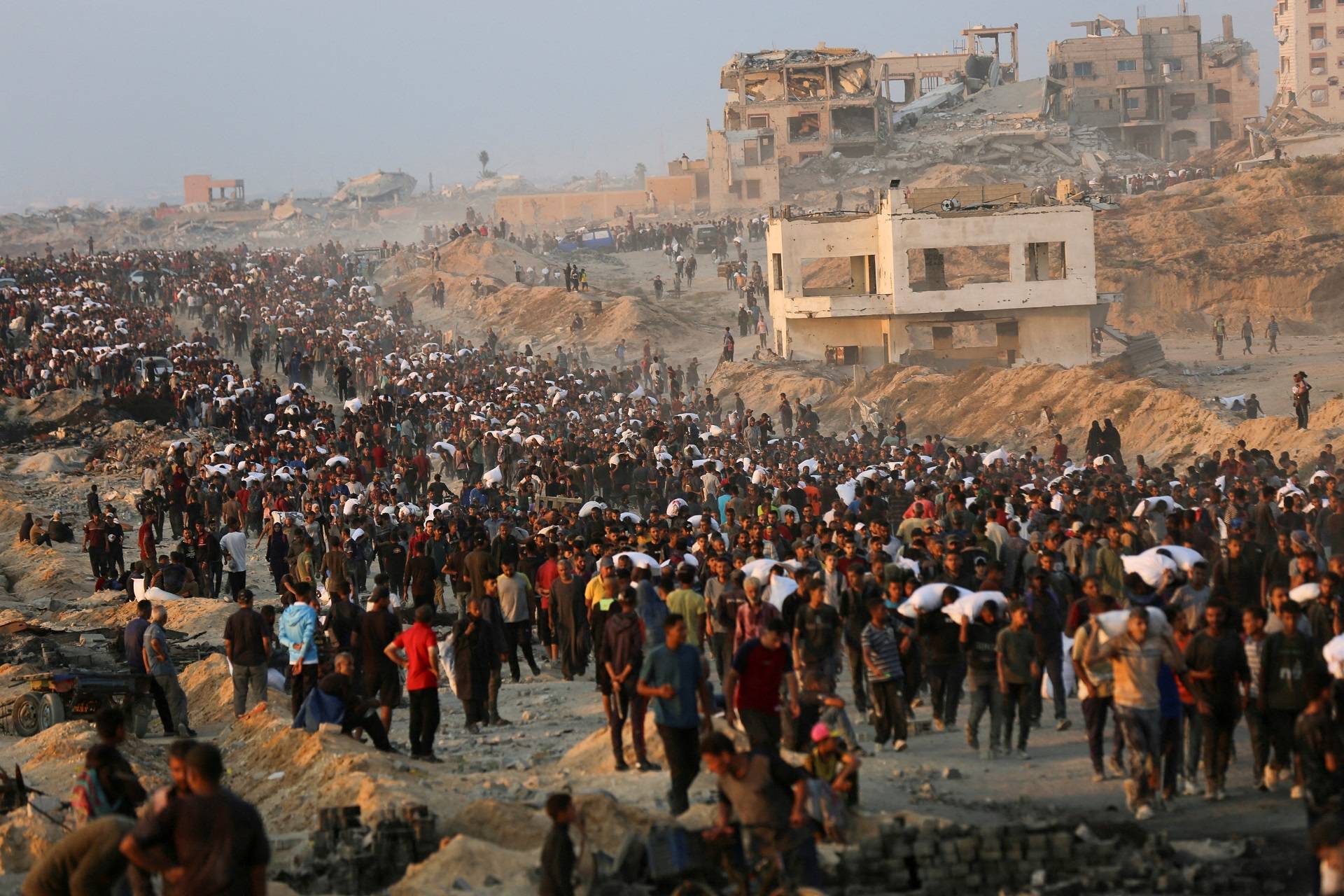 Palestinos se reúnem para receber suprimentos de ajuda em Beit Lahia, no norte da Faixa de Gaza, em 17 de junho de 2025. REUTERS/Stringer