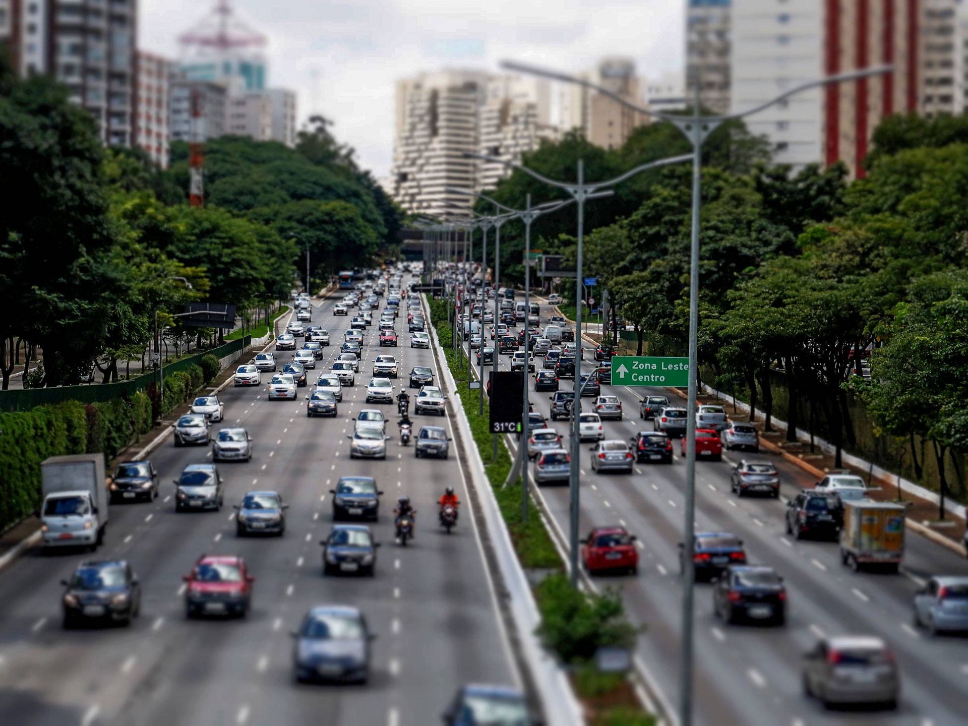Vias públicas de grandes cidades são usadas por motoristas de carros, motos, caminhões e bicicletas (Imagem gerada com auxílio IA/Leonardo Albertino)