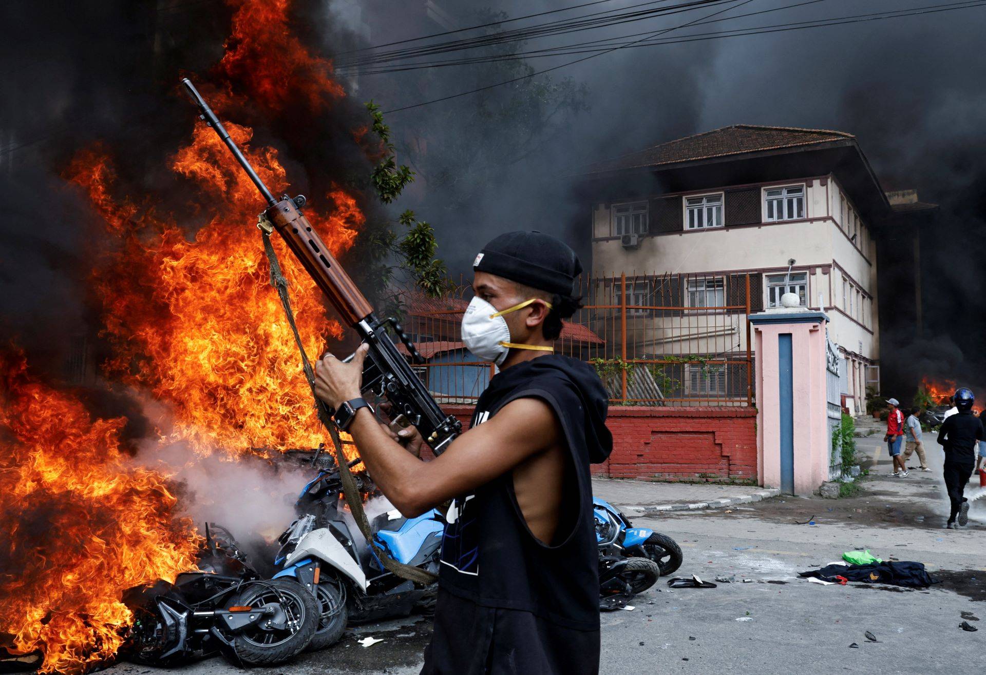 Um manifestante portando uma arma, retirada da Suprema Corte, participa de um protesto anticorrupção em Katmandu, Nepa – 09/09/2025 (Foto: REUTERS/Bikram Rai)