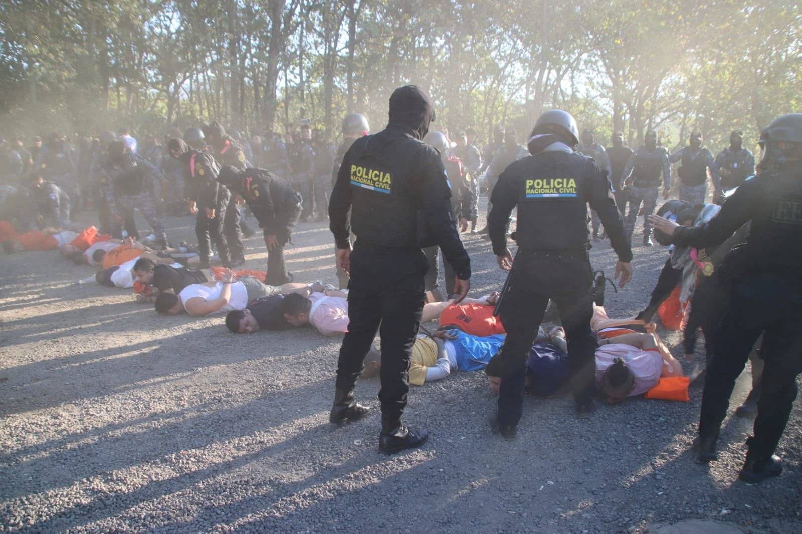 Membros da Polícia Nacional Civil ao lado de detentos recapturados