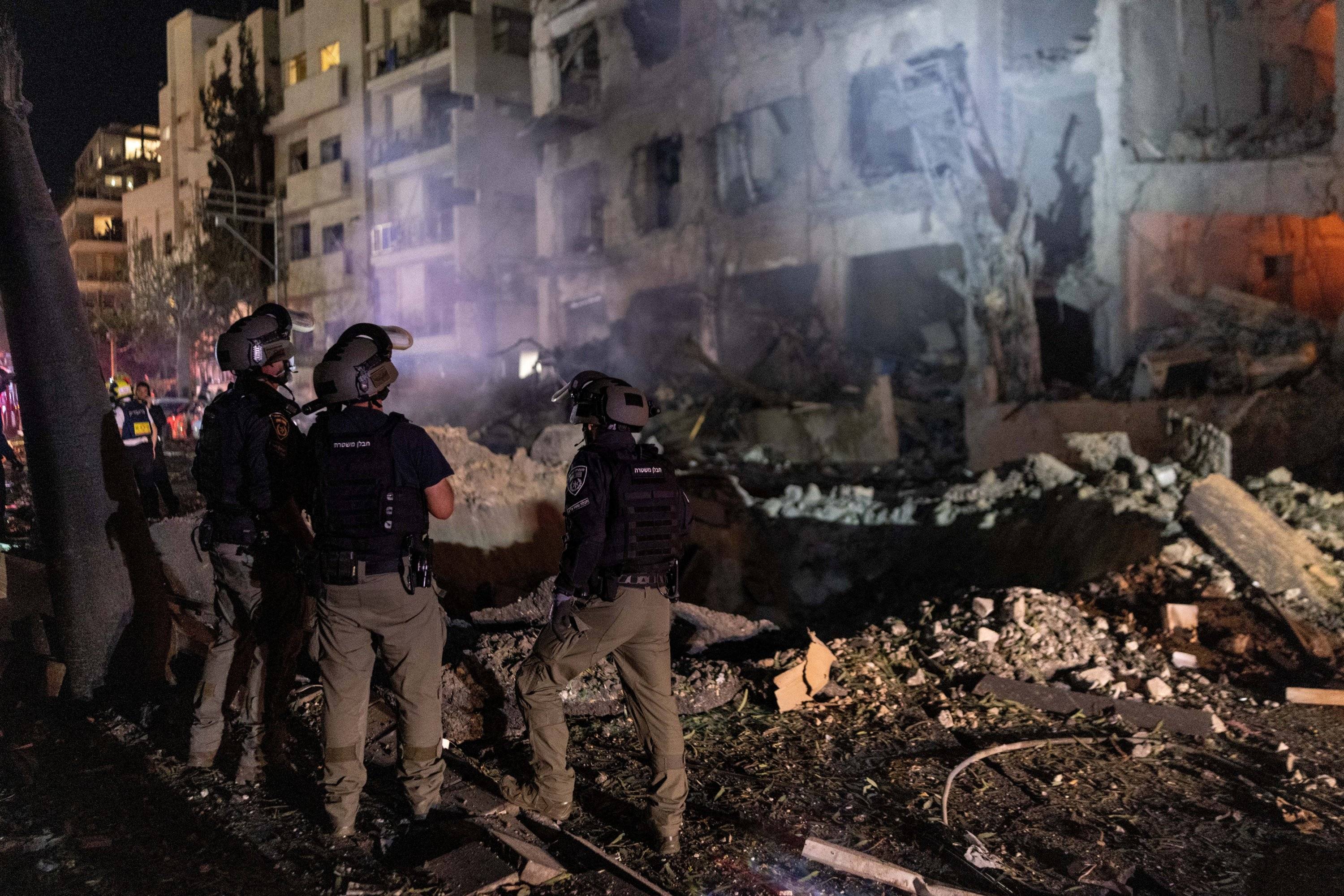 Membros da Unidade de Desativação de Bombas da Polícia Israelense observam o local do impacto de um projétil, após o Irã lançar mísseis contra Israel em resposta aos ataques conjuntos de Israel e dos EUA contra o Irã, em Tel Aviv, Israel, 28 de fevereiro de 2026. REUTERS/Itai Ron