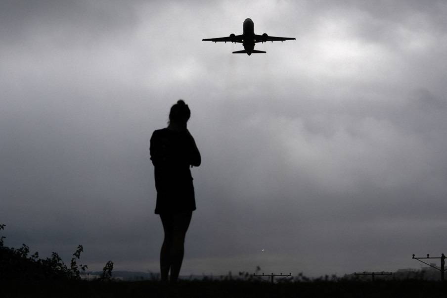 Um corredor observa um avião decolar do Aeroporto Nacional Ronald Reagan, enquanto a paralisação do governo dos EUA continua, em Arlington, Virgínia, Estados Unidos, em 8 de outubro de 2025. REUTERS/Nathan Howard