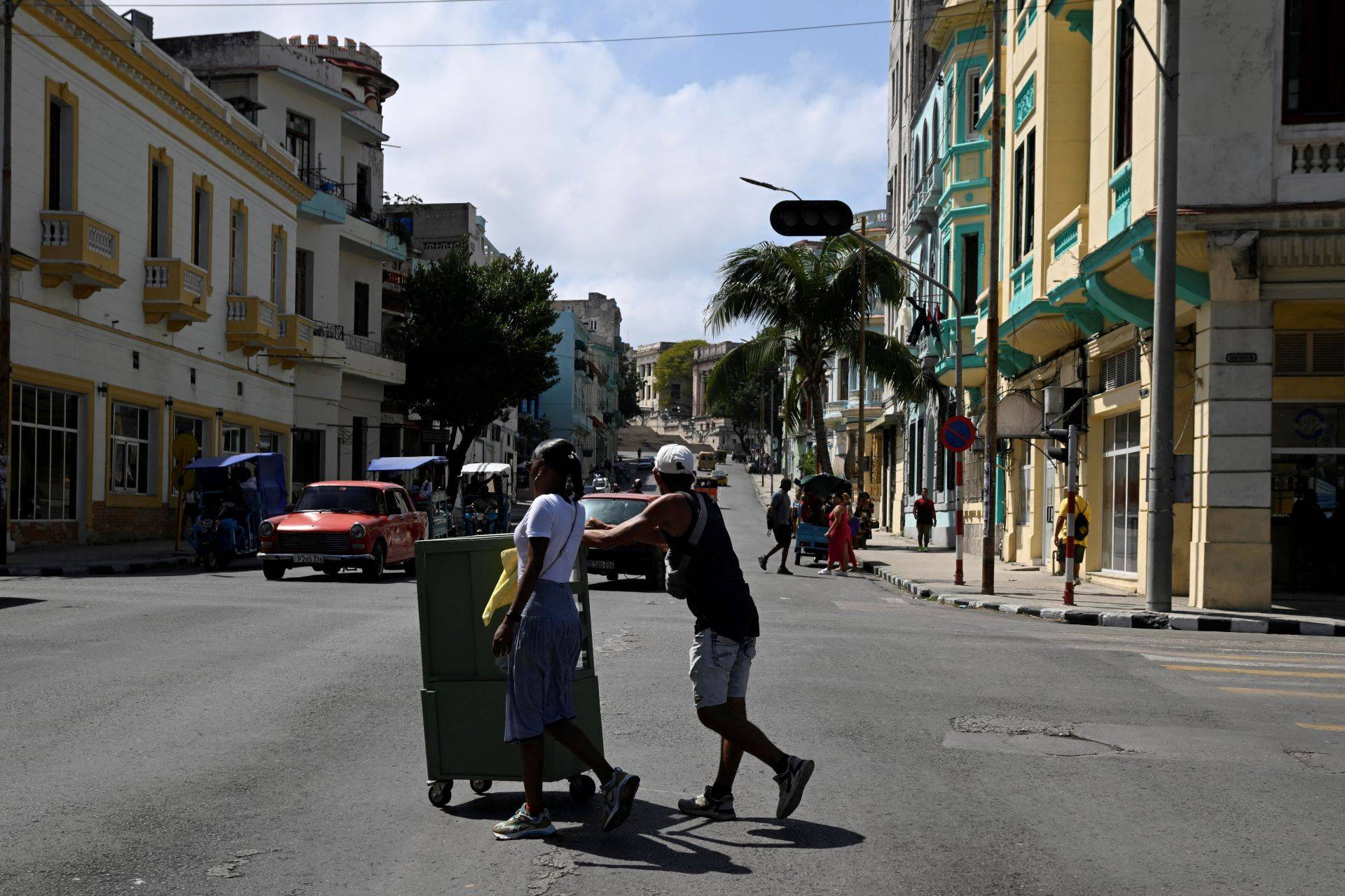 Pessoas atravessam uma avenida enquanto os semáforos estão apagados durante um grande apagão na maior parte do país, em Havana - 04/03/2026 (Foto: REUTERS/Norlys Perez)