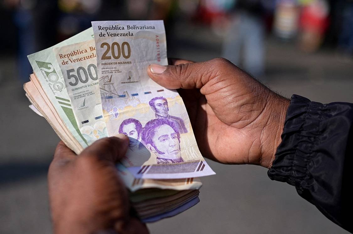 Um homem mostra as novas cédulas de 200 e 500 bolívares em Caracas, Venezuela, em 3 de setembro de 2024. REUTERS/Gaby Oraa