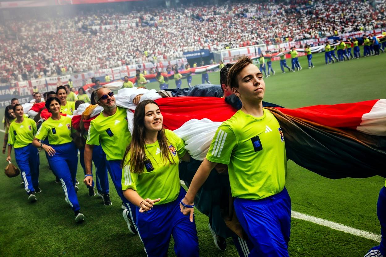 Voluntários carregam as bandeiras da Noruega e da Inglaterra para fora do gramado após a cerimônia pré-jogo da partida da Copa do Mundo entre Inglaterra e Noruega, em Miami Gardens, na Flórida, em 11 de julho de 2026 (Scott McIntyre/The New York Times)