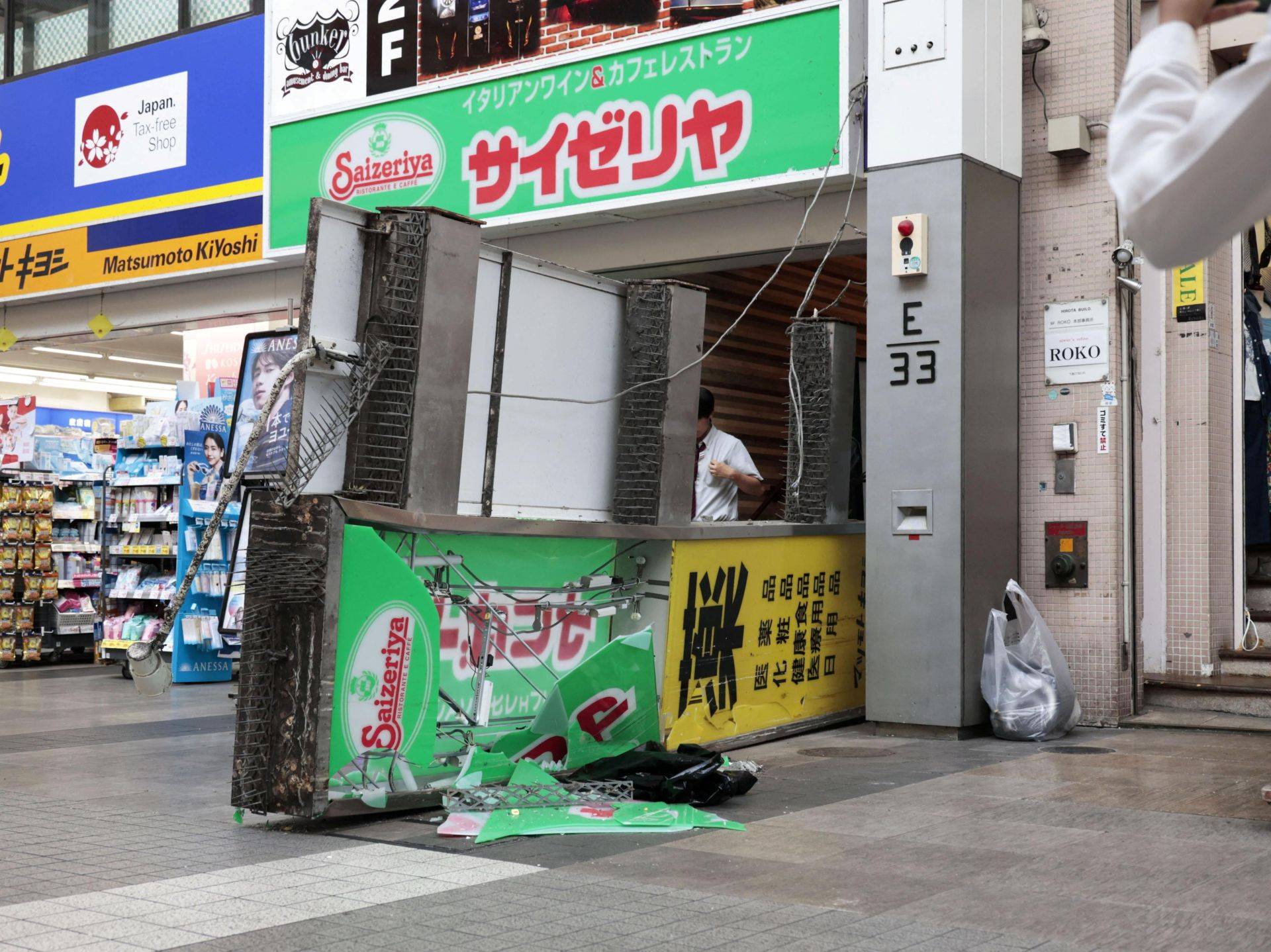 Uma placa danificada e caída do lado de fora de um restaurante após um terremoto com intensidade 7,1 atingir a província de Kumamoto, no sul do Japão - 28/07/2026 (Foto: Kyodo News/via REUTERS)